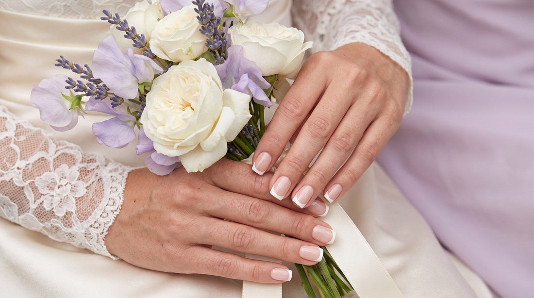 Mains d'une mariée tenant un bouquet avec des press-on nails french